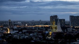 Patung Buddha raksasa setinggi 69 meter berdiri di kuil Wat Paknam Phasi Charoen, Bangkok, pada (12/10/2021). [JACK TAYLOR / AFP]