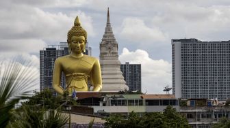 Patung Buddha raksasa setinggi 69 meter berdiri di kuil Wat Paknam Phasi Charoen, Bangkok, pada (12/10/2021). [JACK TAYLOR / AFP]