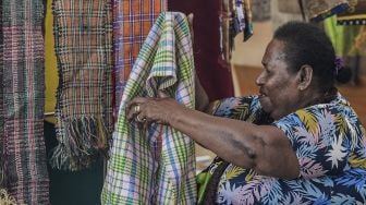 Mama Maria Ambani menata kain tervo di sebuah stan Pameran dan Pagelaran Budaya Nasional di Holtekamp Jayapura, Papua, Kamis (14/10/2021). [ANTARA FOTO/Indrayadi TH]