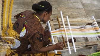 Mama Salonika Ambani menenun kain tervo di sebuah stan Pameran dan Pagelaran Budaya Nasional di Holtekamp Jayapura, Papua, Kamis (14/10/2021). [ANTARA FOTO/Indrayadi TH]