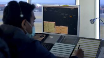 Petugas memantau dan mengatur pergerakan pesawat udara di menara Air Traffic Controller (ATC) Bandara Internasional I Gusti Ngurah Rai, Bali, Rabu (13/10/2021). [ANTARA FOTO/Fikri Yusuf]