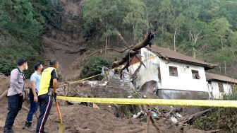 Petugas dan warga mengamati rumah yang rusak tertimbun longsoran bukit akibat gempa di kawasan Trunyan, Kintamani, Bangli, Bali, Sabtu (16/10/2021). ANTARA FOTO/Fikri Yusuf