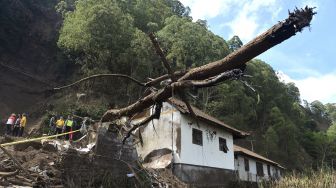 Petugas dan warga mengamati rumah yang rusak tertimbun longsoran bukit akibat gempa di kawasan Trunyan, Kintamani, Bangli, Bali, Sabtu (16/10/2021). [ANTARA FOTO/Fikri Yusuf]