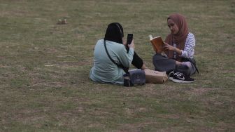 Warga berfoto di Hutan Kota GBK, Kompleks Gelora Bung Karno (GBK), Senayan, Jakarta, Minggu (17/10/2021). [Suara.com/Angga Budhiyanto]