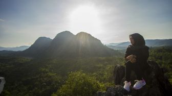 Pengunjung menikmati pemandangan dari atas wisata Bukit Batu Langara di kawasan Geopark Meratus, Kecamatan Loksado, Kabupaten Hulu Sungai Selatan, Kalimantan Selatan, Minggu (17/10/2021). [ANTARA FOTO/Bayu Pratama S]