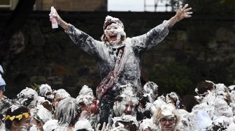 Mahasiswa tahun pertama di University of St Andrews berpartisipasi dalam pertarungan busa saat acara tahunan Raisin Monday di Lower College Lawn, St Andrews, Skotlandia, pada (18/10/2021). [ANDY BUCHANAN / AFP]