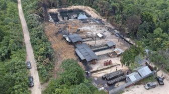 Foto udara saat petugas merobohkan tempat penyulingan minyak mentah ilegal menggunakan alat berat di Jambi Luar Kota, Muarojambi, Jambi, Selasa (19/10/2021). [ANTARA FOTO/Wahdi Septiawan]