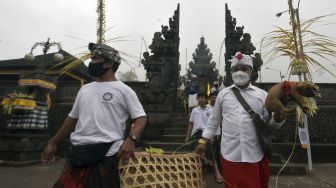 Umat Hindu melakukan ritual penyucian hewan kurban dalam rangkaian pujawali atau upacara persembahyangan di Pura Pasar Agung Besakih Giri Tohlangkir, Karangasem, Bali, Selasa (19/10/2021). [ANTARA FOTO/Nyoman Hendra Wibowo]