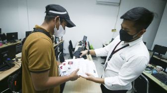 Petugas memeriksa dokumen PT Ant Information Consulting (AIC) saat penggerebekan kantor pinjaman online ilegal di Kelapa Gading, Jakarta, Senin (18/10/2021). [ANTARA FOTO/Rivan Awal Lingga]