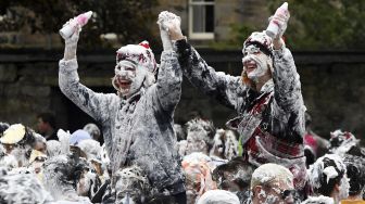 Mahasiswa tahun pertama di University of St Andrews berpartisipasi dalam pertarungan busa saat acara tahunan Raisin Monday di Lower College Lawn, St Andrews, Skotlandia, pada (18/10/2021). [ANDY BUCHANAN / AFP]