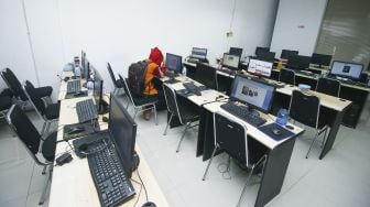 Pegawai PT Ant Information Consulting (AIC) duduk di depan komputer saat penggerebekan kantor pinjaman online ilegal di Kelapa Gading, Jakarta, Senin (18/10/2021). [ANTARA FOTO/Rivan Awal Lingga]