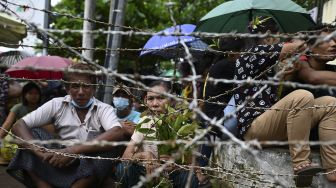 Sejumlah orang menunggu tahanan dibebaskan dari Penjara Insein, Yangon, Myanmar, pada (19/10/2021). [STR / AFP]