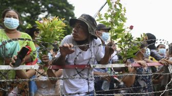 Sejumlah orang menunggu tahanan dibebaskan dari Penjara Insein, Yangon, Myanmar, pada (19/10/2021). [STR / AFP]