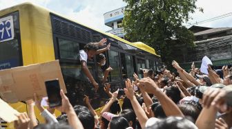 Tahanan yang dibebaskan dari Penjara Insein merayakan dengan kerumunan di Yangon, Myanmar, pada (19/10/2021). [STR / AFP]