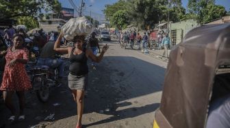 Warga berjalan di jalanan menyusul seruan pemogokan umum yang diluncurkan oleh beberapa asosiasi profesional dan perusahaan untuk mengecam ketidakamanan di Port-au-Prince, Haiti, pada (18/10/2021). [RICHARD PIERRIN / AFP]