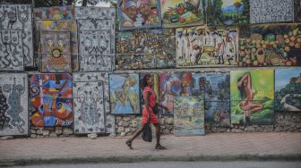 Seorang warga berjalan di jalan sepi di Port-au-Prince, Haiti, pada (18/10/2021). [RICHARD PIERRIN / AFP]