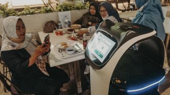 Pengunjung mengambil gambar Robot pramusaji “Bellabot” di Tangcity Mall, Kota Tangerang, Banten, Kamis (21/10/2021). [Suara.com/ Hilal Rauda Fiqry]