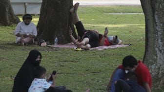 Warga bersantai saat mengunjungi Lapangan Banteng, Jakarta, Minggu (24/10/2021). [Suara.com/Angga Budhiyanto]