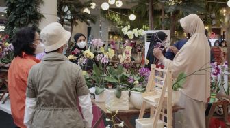 Pengunjung melihat tanaman anggrek pada pameran Creartive Culture Home di Summarecon Mal Serpong, Tangerang, Banten, Minggu (24/10/2021). [Suara.com/Hilal Rauda Fiqry]