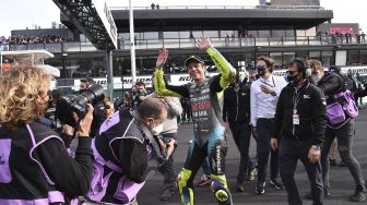 Pembalap Yamaha-SRT Italia Valentino Rossi (tengah) menyapa para penggemarnya setelah Grand Prix MotoGP Emilia-Romagna di Sirkuit Dunia Misano Marco-Simoncelli, Misano Adriatico, Italia, pada (24/10/2021). [ANDREAS SOLARO / AFP]