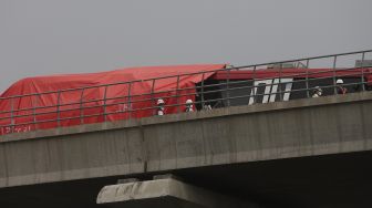 Petugas memeriksa kereta Lintas Rel Terpadu (LRT) yang mengalami kecelakaan di Ruas Cibubur-TMII, Jakarta, Senin (25/10/2021). [Suara.com/Angga Budhiyanto]