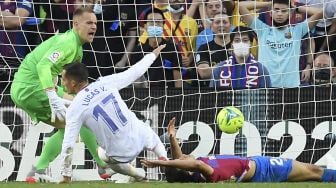 Pemain depan Real Madrid Lucas Vazquez mencetak gol kedua timnya selama pertandingan sepak bola Liga Spanyol antara FC Barcelona dan Real Madrid CF di stadion Camp Nou, Barcelona, Minggu (24/10/2021). [JOSEP LAGO / AFP]