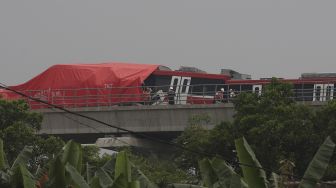 Petugas memeriksa kereta Lintas Rel Terpadu (LRT) yang mengalami kecelakaan di Ruas Cibubur-TMII, Jakarta, Senin (25/10/2021). [Suara.com/Angga Budhiyanto]