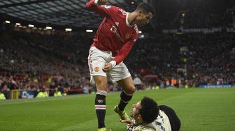 Striker Manchester United Cristiano Ronaldo (kiri) bersaing dengan gelandang Liverpool Curtis Jones (kanan) selama pertandingan sepak bola Liga Premier Inggris antara Manchester United dan Liverpool di Old Trafford, Manchester, Inggris, Minggu (24/10/2021). [OLI SCARFF / AFP]