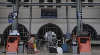 Calon penumpang menunggu kedatangan kereta di Stasiun Pasar Senen, Jakarta, Selasa (26/10/2021). [Suara.com/Angga Budhiyanto]