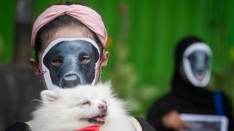 Relawan komunitas pecinta hewan melakukan aksi diam dengan topeng anjing di Solo, Jawa Tengah, Rabu (27/10/2021).  ANTARA FOTO/Mohammad Ayudha