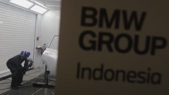 Teknisi melakukan proses perbaikan cat dan bodi mobil BMW saat peresmian Autoglad di Bengkel Autoglad, Jalan Raya Pekayon, Bekasi, Jawa Barat, Kamis (28/10/2021). [Suara.com/Angga Budhiyanto]