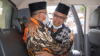 Terdakwa kasus suap sejumlah proyek di Kabupaten Muara Enim yang merupakan Bupati Kabupaten Muara Enim nonaktif Juarsah (kiri) memeluk pendukungnya di dalam mobil tahanan usai menjalani sidang pembacaan putusan di Pengadilan Tipikor Palembang, Sumatera Selatan, Jumat (29/9/2021). ANTARA FOTO/Nova Wahyudi