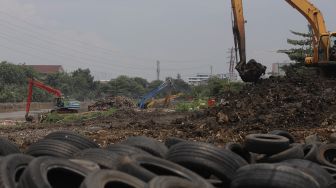 Petugas dari Suku Dinas Sumber Daya Air Jakarta Pusat mengoperasikan alat berat untuk melakukan pengerukan sedimen lumpur di sepanjang aliran Kanal Banjir Barat di kawasan Tanah Abang, Jakarta, Jumat (29/10/2021). [Suara.com/Angga Budhiyanto]