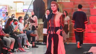 Aktris Irish Bella memperagakan busana di catwalk saat acara penggalangan dana untuk Desa Nggela di Pos Bloc, Jakarta Pusat, Jumat (29/10/2021). [Suara.com/Alfian Winanto]