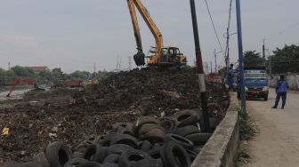 Petugas dari Suku Dinas Sumber Daya Air Jakarta Pusat mengoperasikan alat berat untuk melakukan pengerukan sedimen lumpur di sepanjang aliran Kanal Banjir Barat di kawasan Tanah Abang, Jakarta, Jumat (29/10/2021). [Suara.com/Angga Budhiyanto]