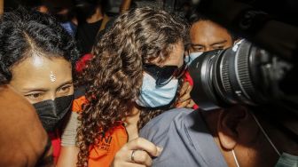 Warga negara Amerika Serikat, Heather Mack (tengah) digiring petugas imigrasi setelah memperoleh status bebas murni di Lapas Kerobokan, Badung, Bali, Jumat (29/10/2021).  ANTARA FOTO/Panji Anggoro