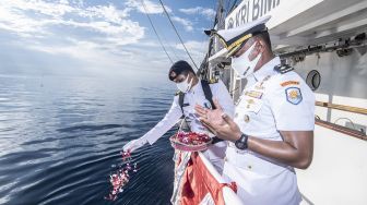 Mayor Laut (P) Sugeng Hariyanto (kanan) dan Kadeplog KRI Bima Suci Kapten Laut (S) Mico Prama (kiri) memanjatkan doa sekaligus tabur bunga di atas geladak KRI Bima Suci, Laut Bali, Bali, Minggu (31/10/2021). [ANTARA FOTO/Muhammad Adimaja]