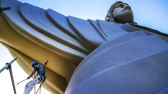 Seorang pekerja terlihat di dekat patung 'Christ the Protector' yang sedang dibangun di Encantado, negara bagian Rio Grande do Sul, Brasil, pada (29/10/2021). [SILVIO AVILA / AFP]