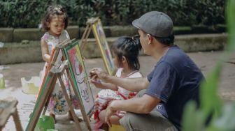 Orang tua mendampingi anaknya bermain di Taman Ekspresi, Karawaci, Kota Tangerang, Banten, Minggu (31/10/2021). [Suara.com/Hilal Rauda Fiqry]