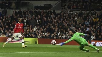 Striker Manchester United Marcus Rashford (kiri) menembak melewati kiper Tottenham Hotspur Hugo Lloris (kanan) untuk mencetak gol ketiga mereka selama pertandingan sepak bola Liga Premier Inggris antara Tottenham Hotspur dan Manchester United di Stadion Tottenham Hotspur, London, Inggris, Sabtu (30/10/2021). [GLYN KIRK / AFP]