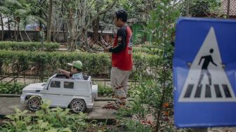 Orang tua mendampingi anaknya bermain di Taman Ekspresi, Karawaci, Kota Tangerang, Banten, Minggu (31/10/2021). [Suara.com/Hilal Rauda Fiqry]