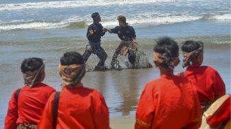 Peserta menampilkan atraksi silek saat Festival Silek on the Sea, di Pantai Kata, Pariaman, Sumatera Barat, Minggu (31/10/2021). [ANTARA FOTO/Iggoy el Fitra]