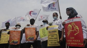 Sejumlah massa buruh membawa poster saat menggelar aksi unjuk rasa di kasawan Patung Kuda Arjuna Wiwaha, Jakarta, Senin (1/11/2021). [Suara.com/Angga Budhiyanto] 