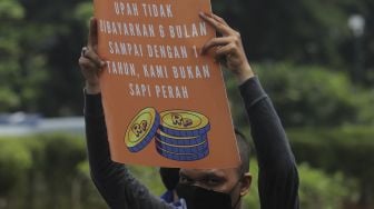 Sejumlah massa buruh membawa poster saat menggelar aksi unjuk rasa di kasawan Patung Kuda Arjuna Wiwaha, Jakarta, Senin (1/11/2021). [Suara.com/Angga Budhiyanto] 