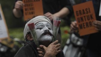 Relawan melakukan aksi teatrikal di kawasan Patung Kuda Arjuna Wiwaha, Jakarta, Senin (1/11/2021). [Suara.com/Angga Budhiyanto]