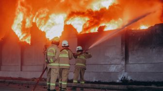 Sejumlah anggota pemadam kebakaran memadamkan api yang membakar pabrik korek api di kawasan Laksana Business Park, Kabupaten Tangerang, Banten. Selasa (2/11).   [Suara.com/Hilal Rauda Fiqry]