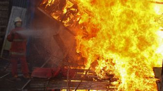 Petugas Dinas Pemadam Kebakaran Kota Surabaya memadamkan kandang burung merpati aduan yang dibakar usai dibongkar di kawasan Karang Asem, Surabaya, Jawa Timur, Senin (1/11/2021).  ANTARA FOTO/Didik Suhartono