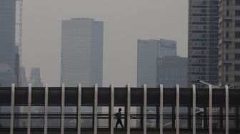 Pekerja menaiki jembatan penyeberangan orang (JPO) saat jam pulang kerja di Jalan Jenderal Sudirman, Jakarta, Rabu (3/11/2021). [Suara.com/Angga Budhiyanto]