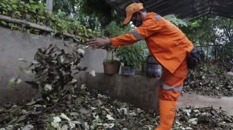 Petugas penanganan prasarana dan sarana umum (PPSU) mencampur sampah organik di Tempat Pengolahan Sampah Terpadu Grogol Selatan, Kebayoran Lama, Jakarta, Kamis (4/11/2021). [Suara.com/Angga Budhiyanto]