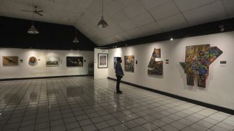 Pengunjung mengamati lukisan yang ditampilkan dalam pameran bertajuk &quot;Hai, Kamu!&quot;, di Balai Budaya, Jakarta, Kamis (4/11/2021). [Suara.com/Angga Budhiyanto]